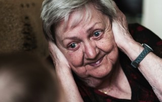 Dame de compagnie à domicile écoutant attentivement une personne âgée atteinte d'Alzheimer, illustrant l'accompagnement bienveillant.