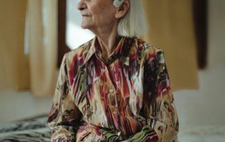 Portrait d'une femme âgée élégante assise dans sa chambre, illustrant le refus d'aide à domicile et la préservation de la dignité